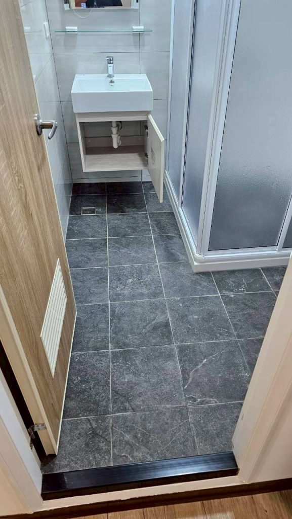 清潔後：地磚潔淨無污漬，洗手台與乾濕分離區域恢復明亮。